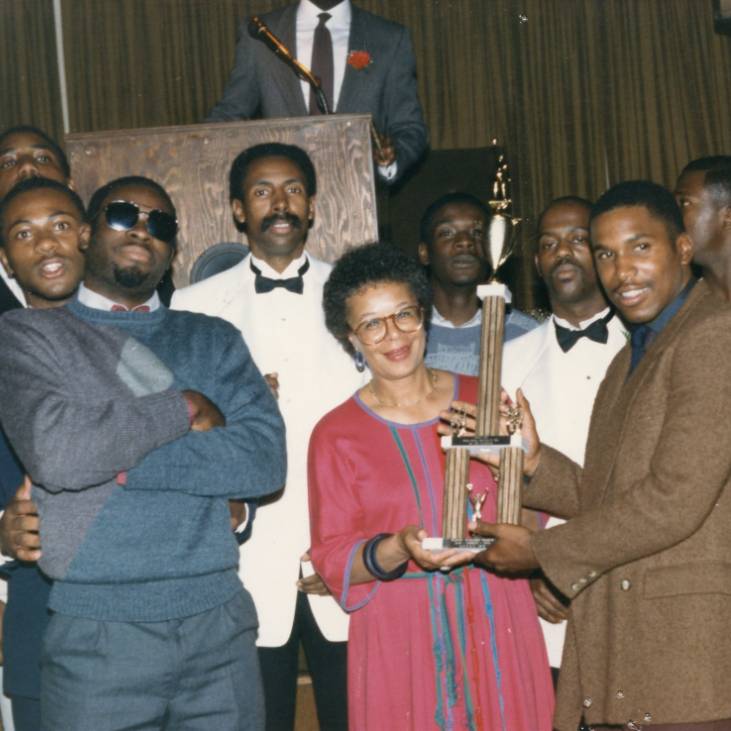 basketball team from 70s celebrating with championship trophy